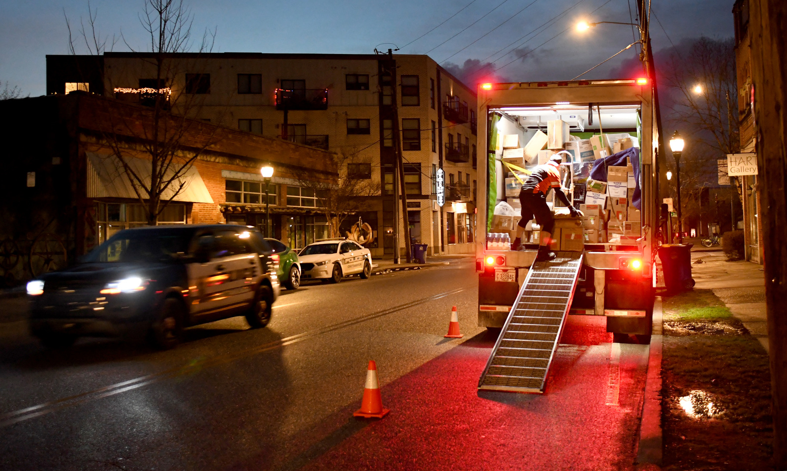 Staff Photo by Robin Rudd / As dawn breaks a police car passes by and deliveries are made to one of the numerous eateries on Main Street as the busy street wakes up on February 21, 2023.