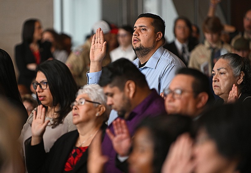 Jose Alfredo Paniagua, originally of Mexico, recites the oath of allegiance during the naturalization ceremony on Wednesday at the Clinton Presidential Center in Little Rock. More photos at arkansasonline.com/223citizens/
(Arkansas Democrat-Gazette/Staci Vandagriff)