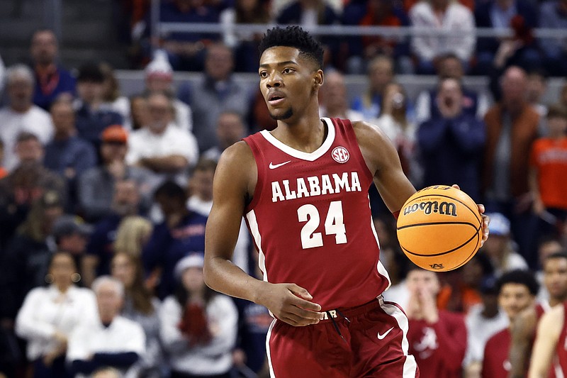 FILE - Alabama forward Brandon Miller brings the ball up during the first half of the team's NCAA college basketball game against Auburn on Feb. 11, 2023, in Auburn, Ala. Police say Miller brought a teammate the gun that was used in a fatal shooting near campus. Tuscaloosa Police investigator Brandon Culpepper testified during a preliminary hearing Tuesday, Feb. 21, that Miller brought Darius Miles’ gun to him on the night of the shooting after Miles texted him and asked him to do so. (AP Photo/Butch Dill, File)