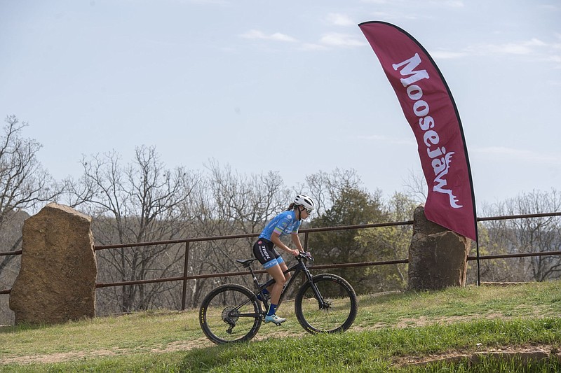 A cyclist warms up on the course of the Moosejaw U.S. Pro Cup at Centennial Park in Fayetteville in this April 19, 2022 file photo. Moosejaw, which was founded in Michigan in 1992 and sold to Walmart Inc. in 2017 for $51 million, is being sold again, this time to retail chain Dick's Sporting Goods, according to a statement from Dick's on Wednesday, Feb. 22, 2023. Moosejaw primarily operates online and sells outdoor equipment and clothing. (NWA Democrat-Gazette/J.T. Wampler)