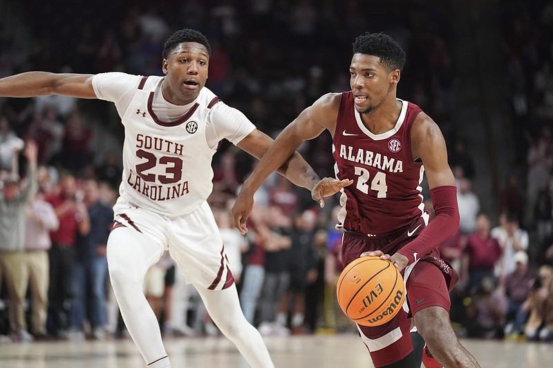 Alabama forward Brandon Miller (24) drives against South Carolina forward Gregory Jackson II (23) on the way to scoring the go-ahead basket in overtime of an NCAA college basketball game Wednesday, Feb. 22, 2022, in Columbia, S.C. Alabama won 78-76. (AP Photo/Sean Rayford)