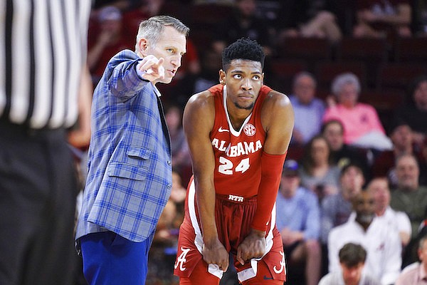 Alabama head coach Nate Oats, left, talks with Brandon Miller (24) during the first half of an NCAA college basketball game Wednesday, Feb. 22, 2023, in Columbia, S.C. Alabama won 78-76. (AP Photo/Sean Rayford)