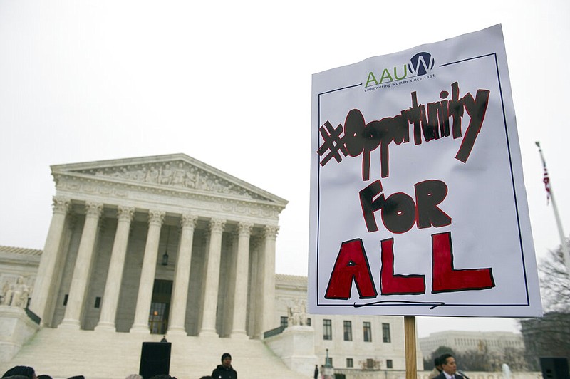 A demonstrator with the American Association of University Women holds a sign outside the Supreme Court in Washington as the court heard oral arguments in an affirmative action case in this Dec. 9, 2015 file photo. (AP/Cliff Owen)