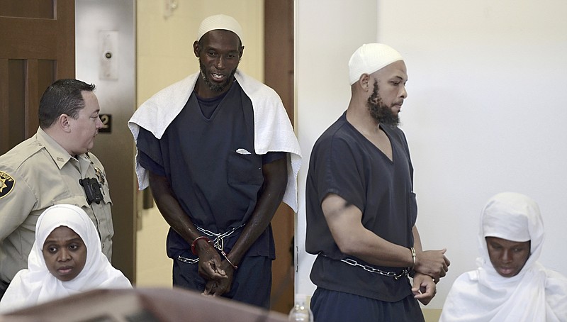 FILE - Defendants, from left, Jany Leveille, Lucas Morton, Siraj Wahhaj and Subbannah Wahhaj enter district court in Taos, N.M., for a detention hearing on Aug. 13, 2018. Leveille, of Haiti, has signed a tentative agreement to plead guilty to weapons charges in exchange for a reduced sentence more than four years after authorities arrested her and four other adults from an extended family at a squalid New Mexico compound and recovered the remains of a 3-year-old boy. A possible trial still looms for the co-defendants who deny charges against them. (Roberto E. Rosales/The Albuquerque Journal via AP, Pool)