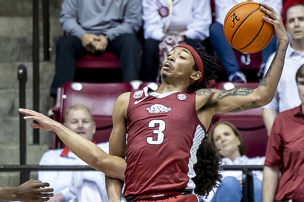 Arkansas guard Nick Smith Jr. (3) grabs a rebound despite having his right arm hooked in the arm of Alabama guard Mark Sears during the second half of an NCAA college basketball game, Saturday, Feb. 25, 2023, in Tuscaloosa, Ala. (AP Photo/Vasha Hunt)