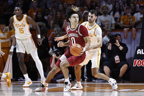 Arkansas guard Anthony Black (0) works for a shot as he's defended by Tennessee guard Santiago Vescovi during the first half of an NCAA college basketball game, Tuesday, Feb. 28, 2023, in Knoxville, Tenn. (AP Photo/Wade Payne)