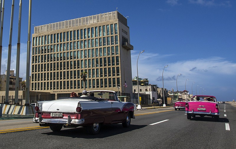 FILE - Tourists ride classic convertible cars on the Malecon beside the United States Embassy in Havana, Cuba, Oct. 3, 2017.(AP Photo/Desmond Boylan, File)