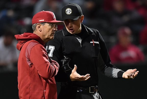 Arkansas coach Dave Van Horn speaks Tuesday, March 15, 2022, with umpire Alex Ransom during the inning of play against Grambling at Baum-Walker Stadium in Fayetteville.
