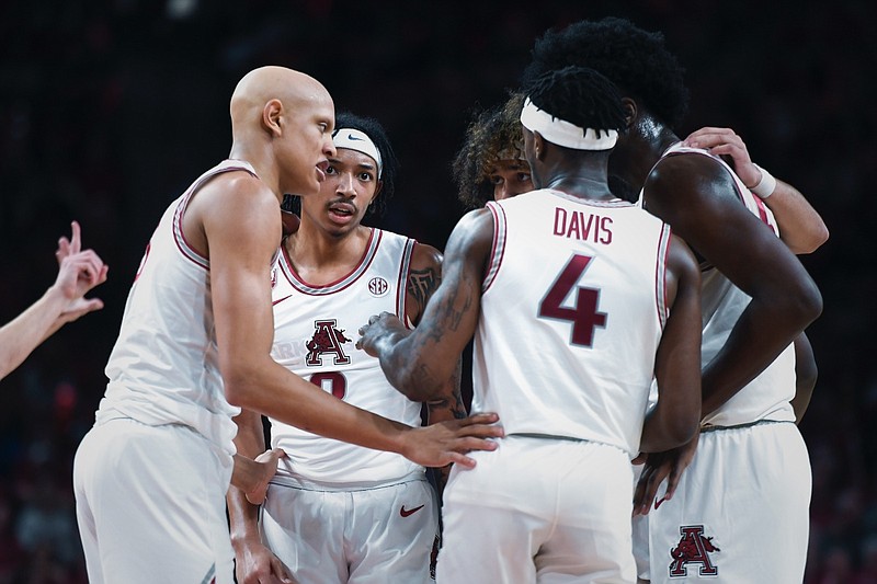 Arkansas players huddle on Tuesday, Feb. 21, 2023, during the second half of a basketball game at Bud Walton Arena in Fayetteville.