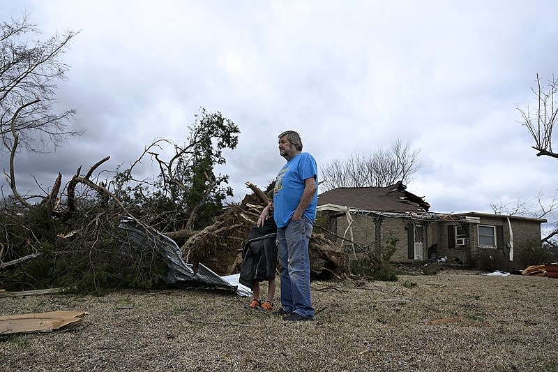 Caiden Bethel, 7, and his grandfather, Charles Fox, stand in the yard of Fox’s brother’s house in Kirby on Friday. The house was severely damaged by an EF2 tornado Thursday night, along with dozens of other homes and farms in the area, according to a report by the National Weather Service. More photos at arkansasonline.com/34Kirby/.
(Arkansas Democrat-Gazette/Stephen Swofford)