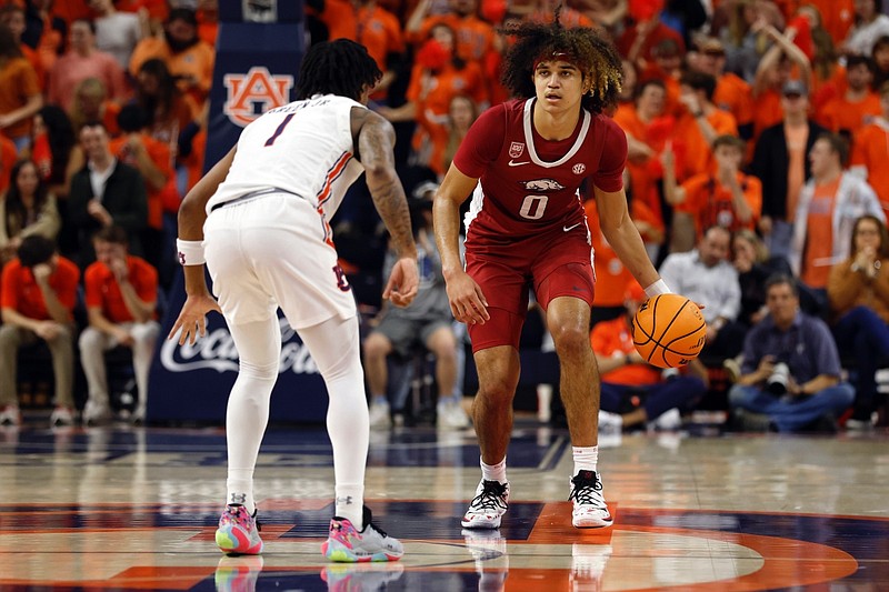 Arkansas guard Anthony Black (0) brings the ball downcourt as Auburn guard Wendell Green Jr. (1) defends during the first half of an NCAA college basketball game Saturday, Jan. 7, 2023, in Auburn, Ala. (AP Photo/Butch Dill)