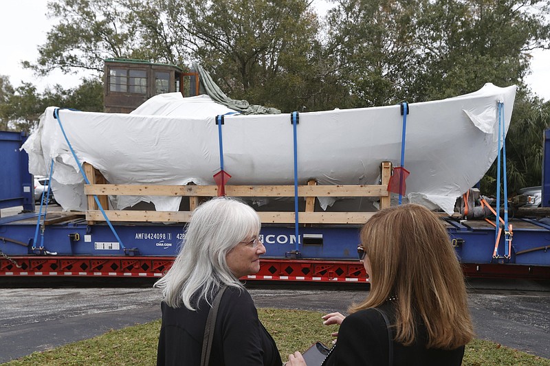 Irene Weiss, left, former Florida Holocaust Museum board chair, and Debbie Sembler, of Pinellas Park, watch as a Danish boat that helped Jewish families escape the Holocaust, is transported into a warehouse, where it will be restored at Elite Exterior Restoration on Wednesday, Dec. 21, 2022, in Largo, Fla. (Jefferee Woo/Tampa Bay Times via AP)