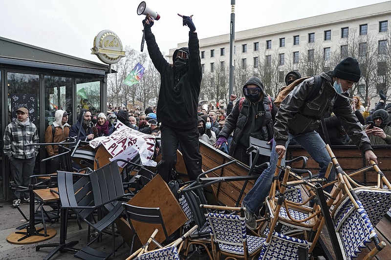 Protesters stand on a barricade during a demonstration in Lyon, central France, Tuesday, March 7, 2023. Demonstrators were marching across France on Tuesday in a new round of protests and strikes against the government's plan to raise the retirement age to 64, in what unions hope to be their biggest show of force against the proposal. (AP Photo/Laurent Cipriani)