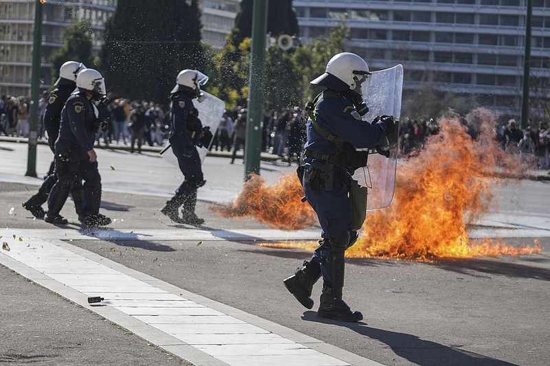 Riot police try to avoid the flames of a molotov cocktail thrown byprotesters during a protest Wednesday for victims of the rail disaster outside of the Parliament in central Athens. More photos at arkansasonline.com/309greece/.
(AP/Petros Giannakouris)
