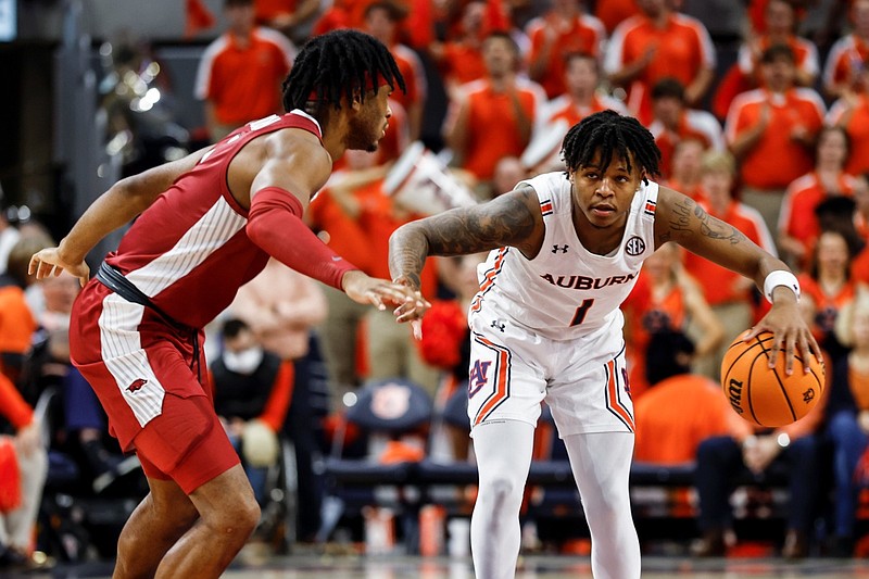 Auburn guard Wendell Green Jr. (1) dribbles the ball as Arkansas guard Ricky Council IV (1) defends during the second half of an NCAA college basketball game Saturday, Jan. 7, 2023, in Auburn, Ala. (AP Photo/Butch Dill)