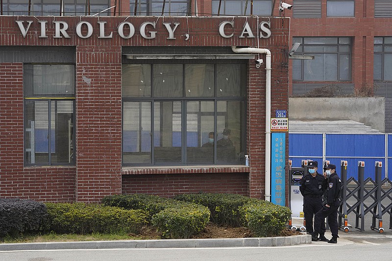 Security officers stand guard outside the Wuhan Institute of Virology in Wuhan, China, during a February 2021 visit by a World Health Organization team. Congress gave final approval Friday for an order to declassify intelligence related to the institute, citing “potential links” between research there and the outbreak of covid-19.
(AP/Ng Han Guan)