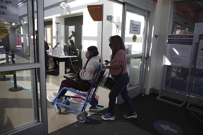 A long covid patient is wheeled into a hospital by her mother in Sacramento, Calif., in October 2021.
(The New York Times/Jim Wilson)