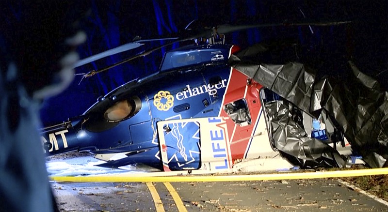 This image from a video shows a wrecked helicopter in Macon Country, N.C. Friday, March 10, 2023. A patient and three crew members survived when the medical transport helicopter crashed Thursday evening. (WLOS-TV via AP)