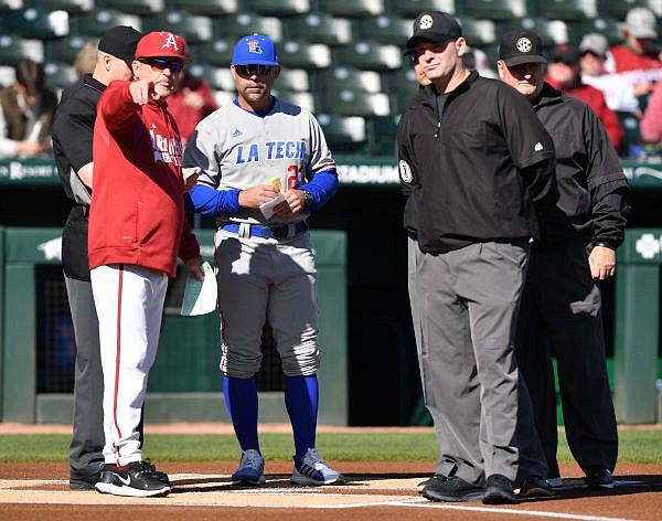 Arkansas coach Dave Van Horn discusses the ground rules Friday, March 10, 2023, with Louisiana Tech coach Lane Burroughs and the umpire crew before the start of the Razorbacks’ 7-4 win at Baum-Walker Stadium in Fayetteville. Visit nwaonline.com/photo for today's photo gallery. ...(NWA Democrat-Gazette/Andy Shupe)