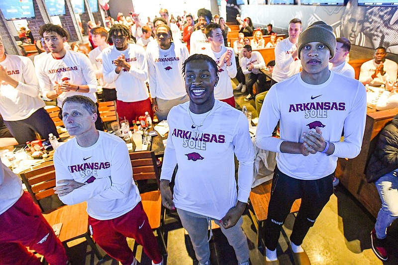 Arkansas guard/forward Jordan Walsh (front, from right), Arkansas guard Davonte Davis, Arkansas head coach Eric Musselman and others react, Sunday, March 12, 2023, after it was revealed the Razorbacks will be a no. 8 seed and play Illinois in the NCAA National Tournament during a Selection Sunday watch party at Walk-On’s Sports Bistreaux in Fayetteville.