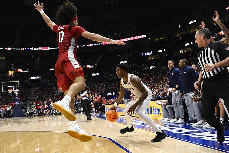 Arkansas guard Anthony Black (0) leaps past Auburn guard K.D. Johnson who pulls up to shoot during the second half of an NCAA college basketball game in the second round of the Southeastern Conference tournament, Thursday, March 9, 2023, in Nashville, Tenn. Arkansas won 76-73. (AP Photo/John Amis)