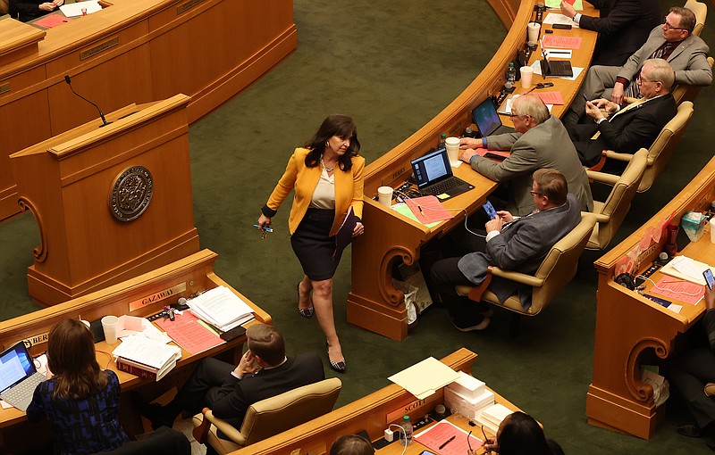 Rep. Mindy McAlindon (center), R-Centerton, returns to her seat after listening to debate about SB66 on the floor of the House of Representatives at the Arkansas state Capitol on Tuesday, March 14, 2023. (Arkansas Democrat-Gazette/Colin Murphey)