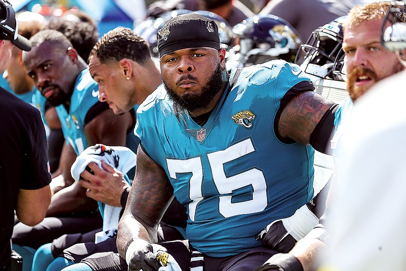 In this Oct. 23, 2022, file photo, Jawaan Taylor sits on the Jaguars sideline during a game against the Giants in Jacksonville, Fla. (Associated Press)