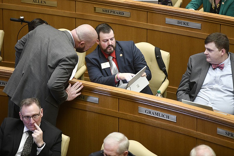 Rep. Justin Gonzales (center left), R-Okolona, talks with Rep. Ryan Rose, R-Van Buren, after Gonzales presented Senate Bill 81, which would amend the law concerning obscene materials loaned by a library, during a meeting of the House at the state Capitol in Little Rock on Wednesday.
(Arkansas Democrat-Gazette/Stephen Swofford)