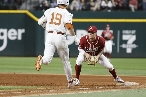 Arkansas first baseman Brady Slavens waits on a throw while Texas infielder Mitchell Daly (19) runs toward the bag during a game Friday, Feb. 17, 2023, in Arlington, Texas. The Longhorns will have a long history against multiple teams, like the Razorbacks, in the new-look SEC, but won't be able to play them all on an annual basis.
