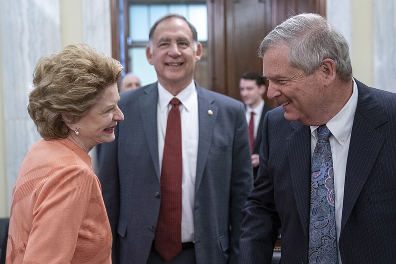 Chairwoman Sen. Debbie Stabenow, D-Mich., (left) and Ranking Member Sen. John Boozman, R-Ark., speak Thursday with Agriculture Secretary Tom Vilsack before a hearing of the Senate Agriculture, Nutrition, and Forestry Committee on Capitol Hill.
(AP/Alex Brandon)