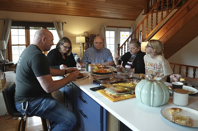 Doug Whitney, center, eats breakfast with his family in Manson, Wash., on Nov. 5, 2022. Whitney inherited the same gene mutation that gave Alzheimer's disease to his mother, brother and generations of other relatives by the unusually young age of 50. Doug is a healthy 73, his mind still sharp. Somehow, he escaped his genetic fate. (AP Photo/Shelby Lum)