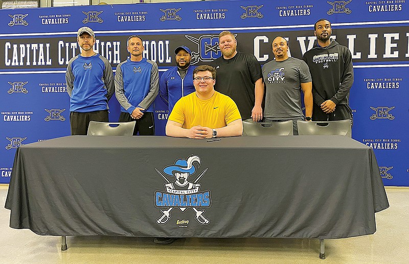 Sam Albert of Capital City (seated) signs a letter for track and field at the University of Missouri. Standing (from left) are Capital City trck and field assistant coach Magnus Holmstrum, Capital City track and field head coach Scott Gschwender Capital City track and field assistant coaches Charles Miller, Chris Lueckenhoff, Alonzo Findley and Cameron Grant. (Kyle McAreavy/News Tribune)