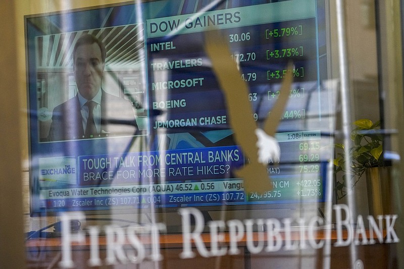 A television screen displaying financial news is seen inside one of First Republic Bank's branches in the Financial District of Manhattan, Thursday, March 16, 2023. The S&P 500 was 0.8% higher in midday trading after erasing an earlier loss of nearly that much following reports that First Republic Bank could receive financial assistance or sell itself to another bank. (AP Photo/Mary Altaffer)