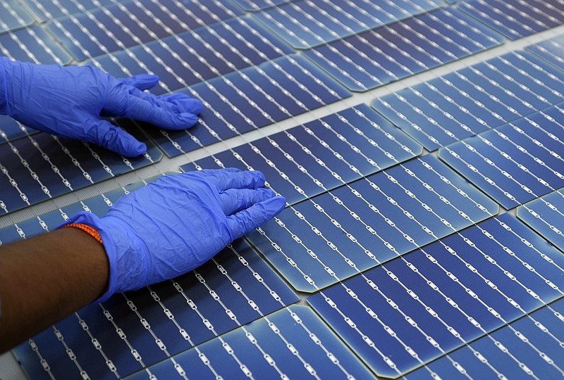 FILE - A worker makes arrangements of solar cells at Premier Energies Solar on the outskirts of Hyderabad, India, Jan. 25, 2023. (AP Photo/Mahesh Kumar A., File)