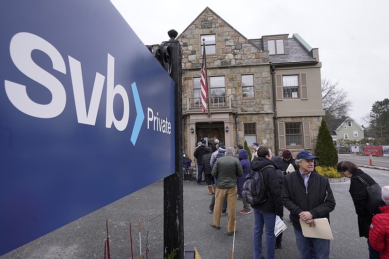 FILE - Customers and bystanders form a line outside a Silicon Valley Bank branch location, Monday, March 13, 2023, in Wellesley, Mass. (AP Photo/Steven Senne, File)