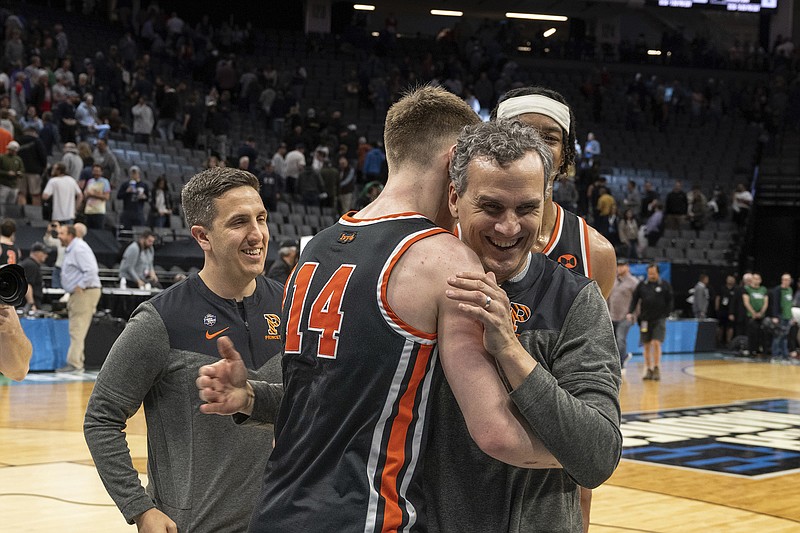AP photo by José Luis Villegas / Princeton basketball coach Mitch Henderson embraces guard Matt Allocco (14) after the Tigers beat South Region No. 2 seed Arizona in the first round of the NCAA tournament Thursday in Sacramento, Calif.