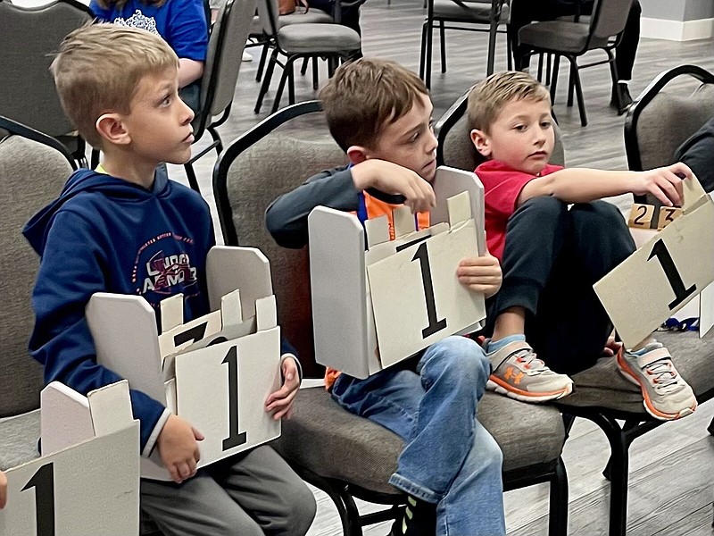 (From left) Second-graders Brinn Butler, Aiden Jackson and Paxton Keathley compete in a Bible quiz competition March 18 at their home church, Brockington Road Church of the Nazarene in Sherwood. Top scorers at a districtwide competition April 15 will qualify to participate in their denomination’s World Quiz competition in Indianapolis.
(Arkansas Democrat-Gazette/Frank E. Lockwood)