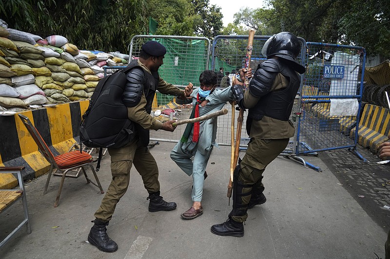Police detain a supporter of former Prime Minister Imran Khan during a search operation Saturday in the Khan’s residence, in Lahore, Pakistan. More photos at arkansasonline.com/319pakistan/.
(AP/K.M. Chaudary)