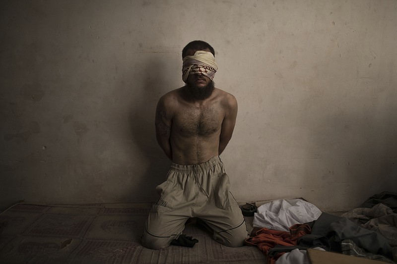 FILE - A suspected Islamic State fighter sits in a basement as Iraqi forces continue their advance against Islamic State militants in the Old City of Mosul, Iraq, July 3, 2017. (AP Photo/Felipe Dana, File)