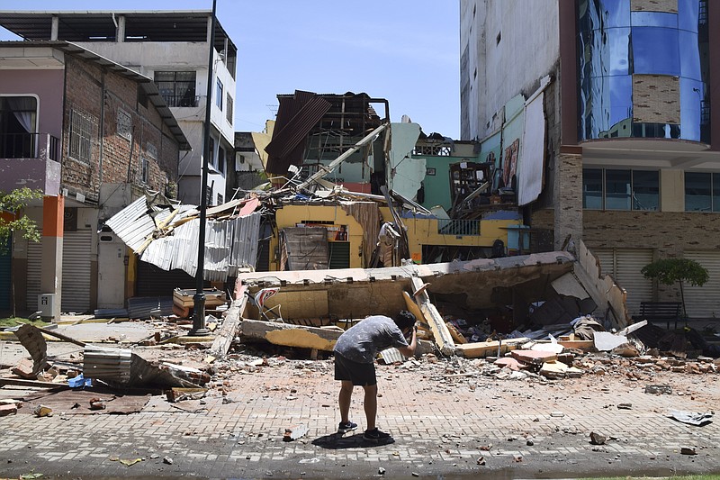 A man takes a photo of a building that collapsed after an earthquake shook Machala, Ecuador, Saturday, March 18, 2023. The U.S. Geological Survey reported an earthquake with a magnitude of about 6.8 that was centered just off the Pacific Coast, about 50 miles (80 kilometers) south of Guayaquil. (AP Photo/Jhonny Crespo)