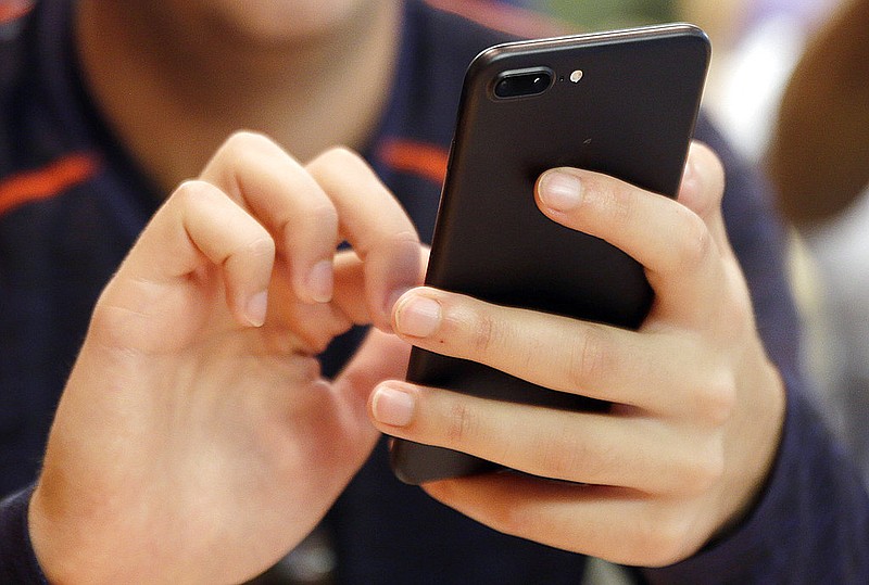 A person uses a smartphone in Chicago in this Sept. 16, 2017 file photo. A new analysis suggests that increased social media use could be one factor contributing to a rise in teen suicide. (AP Photo)