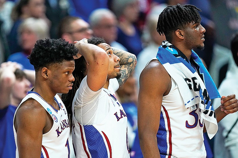 Kansas players watch from the bench in the second half of Saturday’s NCAA Tournament second-round game against Arkansas in Des Moines, Iowa. (Associated Press)