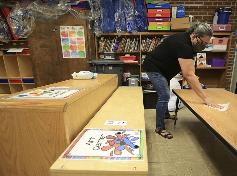 Pre-K teacher Abbie Chapman cleans items in her classroom at College Station Elementary School in College Station in this Aug. 18, 2020 file photo. Chapman was sanitizing the classroom ahead of the first day of classes, about five months after the first case of covid-19 was detected in Arkansas. (Arkansas Democrat-Gazette/Staton Breidenthal)