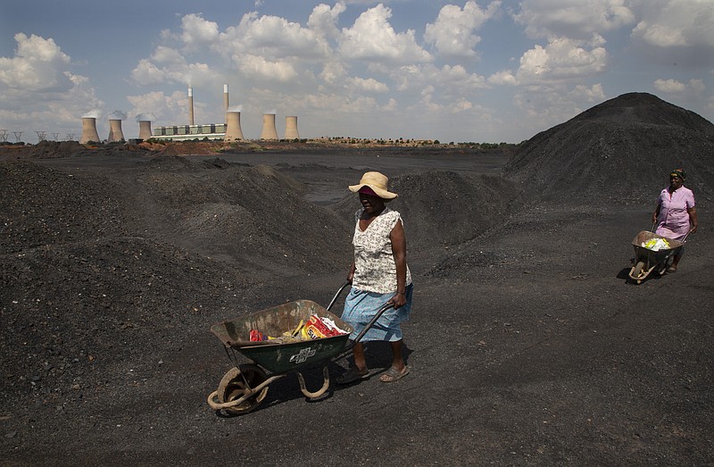 FILE - Women push wheelbarrows atop a coal mine dump at the coal-powered Duvha power station, near Emalahleni east of Johannesburg, Nov. 17, 2022. Humanity still has a chance, close to the last one, to prevent the worst of climate change’s future harms, a top United Nations panel of scientists said Monday, March 20, 2023. But doing so requires quickly slashing carbon pollution and fossil fuel use. (AP Photo/Denis Farrell, File)