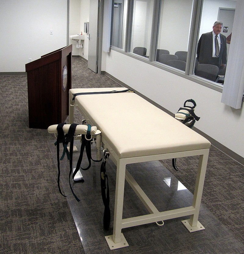 FILE - The execution chamber at the Idaho Maximum Security Institution is shown as Security Institution Warden Randy Blades look on in Boise, Idaho on Oct. 20, 2011. A bill that would allow Idaho to kill condemned inmates by firing squad is headed to the governor's desk after passing the Legislature with a veto-proof majority. Firing squads will only be used if the state cannot obtain the drugs needed for lethal injections. (AP Photo/Jessie L. Bonner, File)