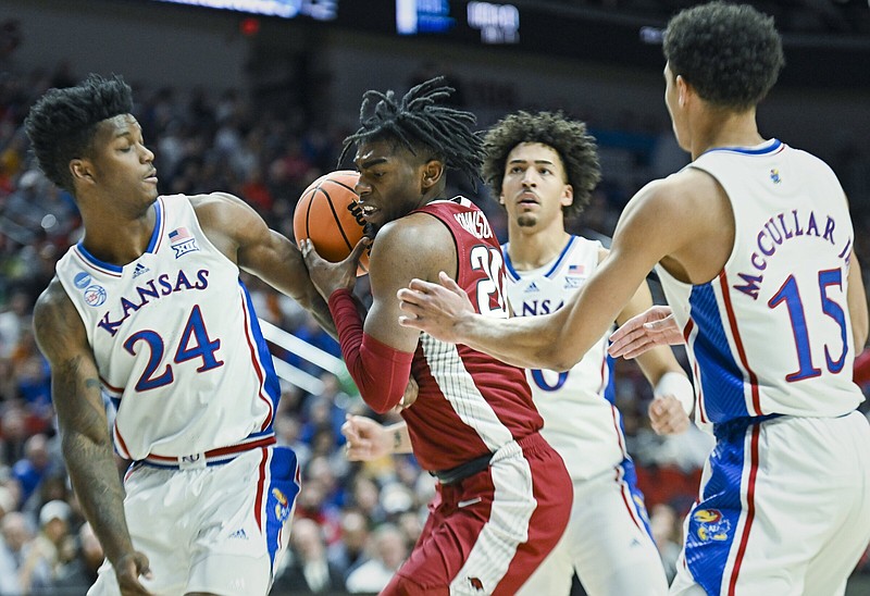 Arkansas forward Kamani Johnson (center) pulls down a rebound during Saturday’s NCAA Men’s Tournament second-round game against Kansas. Arkansas and West Region semifinal opponent Connecticut are expecting tonight’s game to a battle around the rim.
(NWA Democrat-Gazette/Charlie Kaijo)