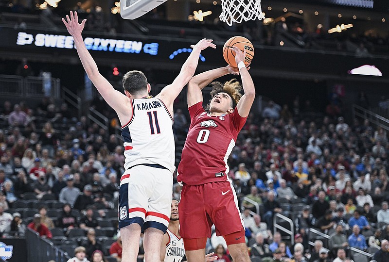 Arkansas guard Anthony Black (right) goes up for a shot Thursday while being defended by Connecticut forward Alex Karaban during the Razorbacks’ loss to the Huskies in Las Vegas.
(NWA Democrat-Gazette/Charlie Kaijo)