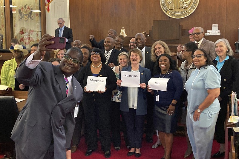 North Carolina state Rep. James Roberson, D-Wake, takes a picture with fellow House Democratic members on the House floor after the chamber gave final approval to a Medicaid expansion agreement in Raleigh, N.C., on Thursday, March 23, 2023. The affirmative vote means the legislation laying out expansion details now goes to the desk of Democratic Gov. Roy Cooper. (AP Photo/ Gary Gary Robertson)