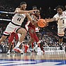 UConn's Andre Jackson Jr. (44) and Tristen Newton (2) reach for the ball against Arkansas' Kamani Johnson (20), middle, in the first half of a Sweet 16 college basketball game in the West Regional of the NCAA Tournament, Thursday, March 23, 2023, in Las Vegas. (AP Photo/David Becker)