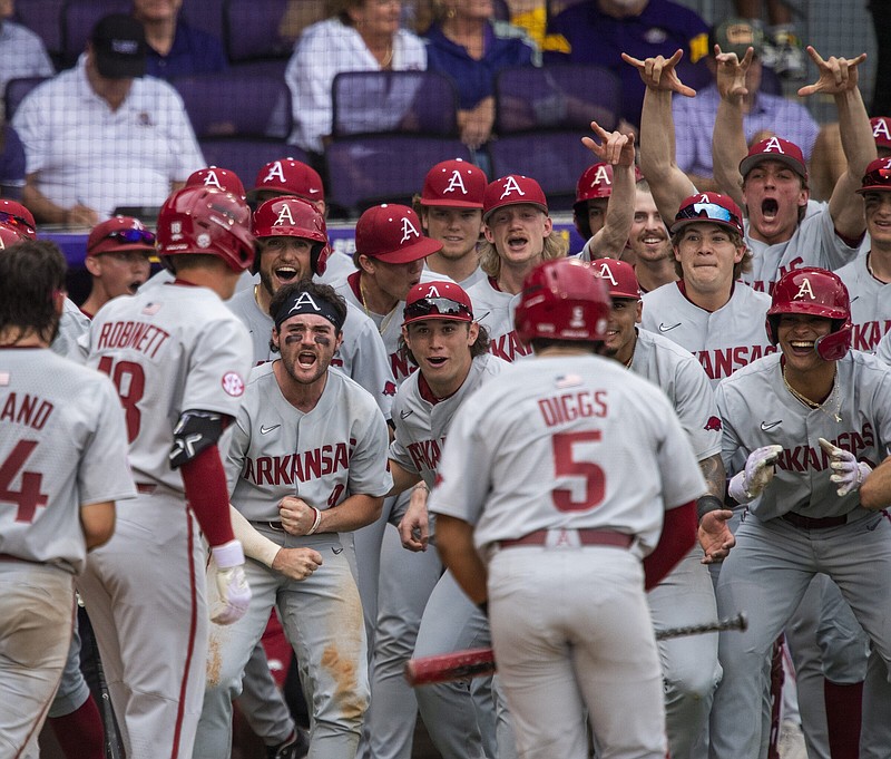 Arkansas pinch-hitter Reese Robinett (far left) is greeted by teammates after he hit a three-run home run with one out to put No. 3 Arkansas ahead 4-1 in the 10th inning Friday against top-ranked LSU in Baton Rouge. The Razorbacks won 9-3. More photos at arkansasonline.com/325ualsu/
(The Advocate/AP/Michael Johnson)